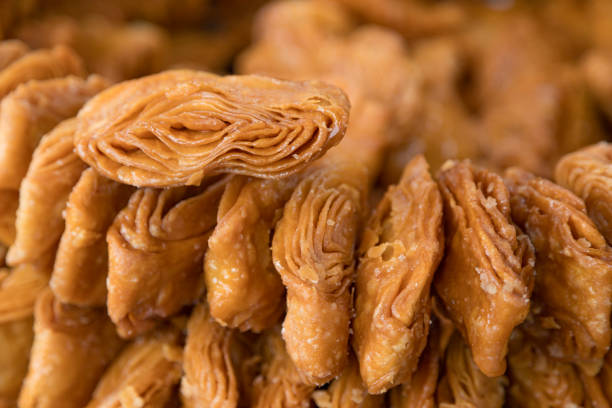 Close-up of intricately designed Khaja with a dusting of sugar 